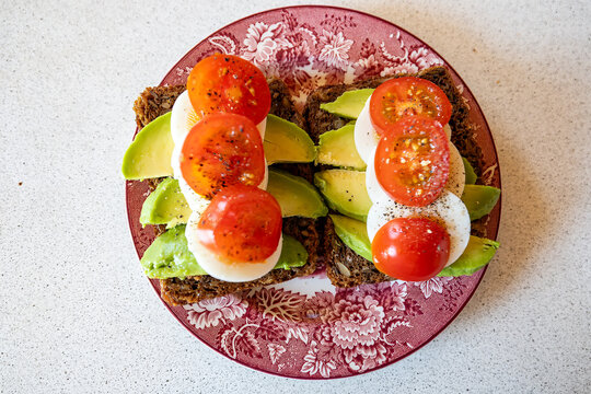 Hirtshals, Denmark A healthy open-faced sandwich with dark bread, avocado, tomato and eggs.