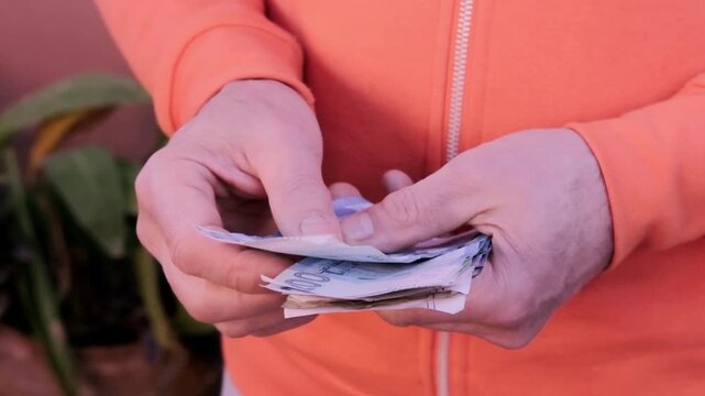 closeup male hands hold Moroccan dirham money, count paper dirham banknotes, concept cash payments, monetary savings, save for vacation, exchange and cashing currency
