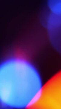Abstract Defocused Color Lights Moving on Dark Background. Soft blue, pink, red and yellow light shapes shift.