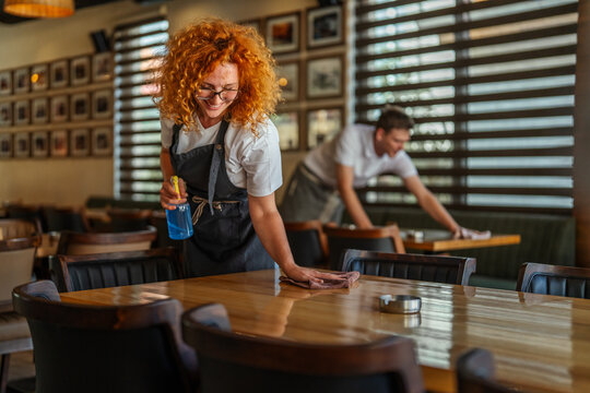 Restaurant staff cleaning tables for hygiene and service