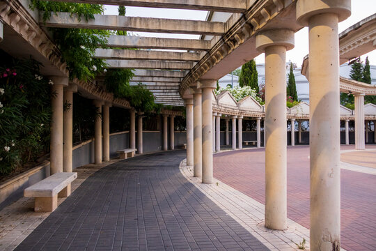 View of the curved colonnade with stone pillars and a paved walkway in the old town of Calp, Comunidad Valenciana, Spain.