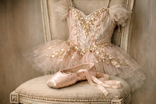 Pair of ballet shoes placed on top of a chair, perfect for use in still life or lifestyle images