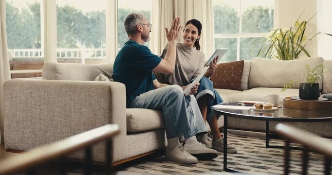 Finance, tablet or couple high five in home for mortgage pay off, under budget or loan settlement. Happy, mature people and celebration with tech for credit balance, debt free or financial security