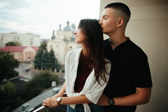 Young couple enjoying tender moment on city balcony