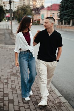 Young couple walking together on city sidewalk