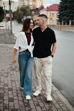 Young couple walking together on city sidewalk