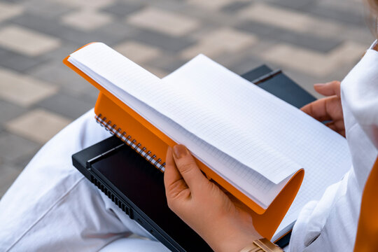 woman hands turning pages of notebook on laptop keyboard, office routine and remote work organization