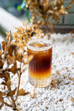 Iced bumble coffee fluted glass on white pebble bed
