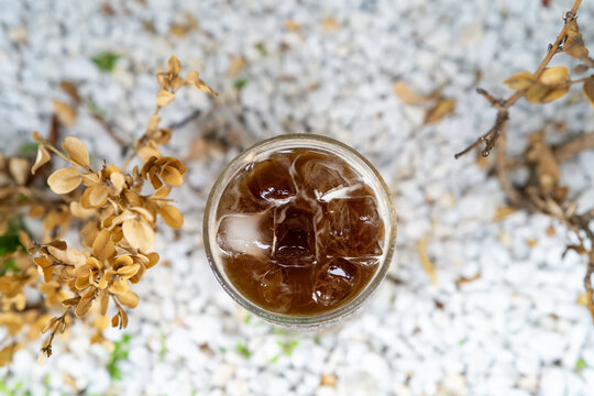 Top view of iced espresso tonic glass on white pebbles