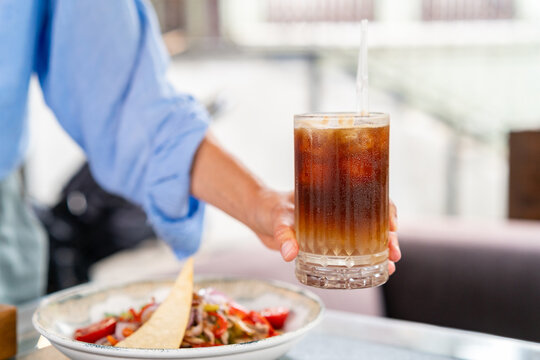 Close up of woman hand holding glass of iced espresso tonic
