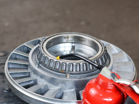 Lubricating a tapered roller bearing on a metal component with an oiler.