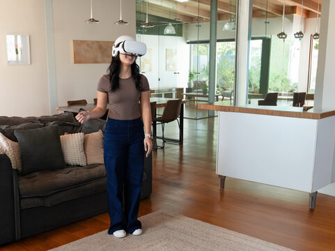 African American female wearing VR headset and holding controller while exploring open living space