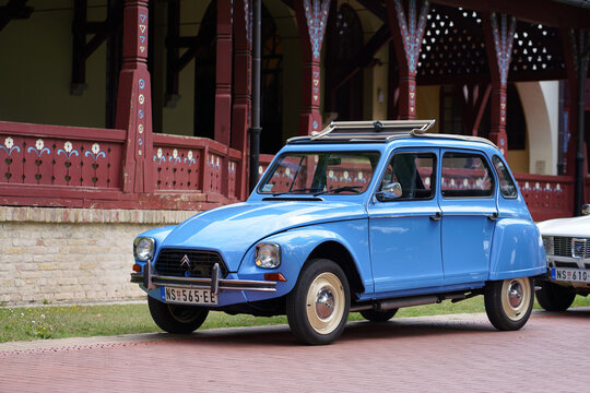 Blue oldtimer Citroen Dyane 6 classic hatchback (related: 2CV) with open canvas roof, front three quarter view, parked on paved path, Palic, Serbia, July 5, 2026