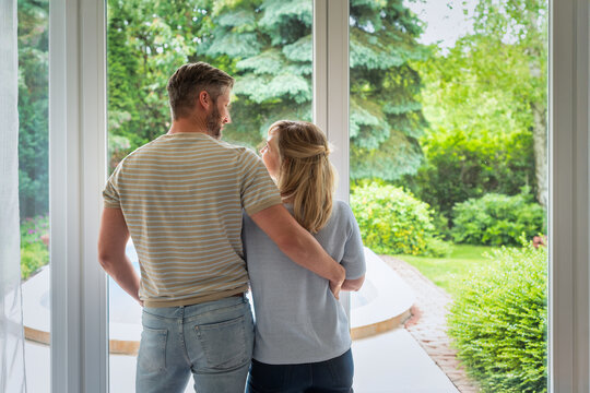 Rear view of a middle-aged couple looking out the window