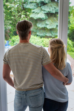Rear view of a middle-aged couple looking out the window