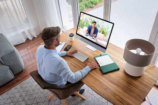 Confident middle-aged man using his computer at home and working