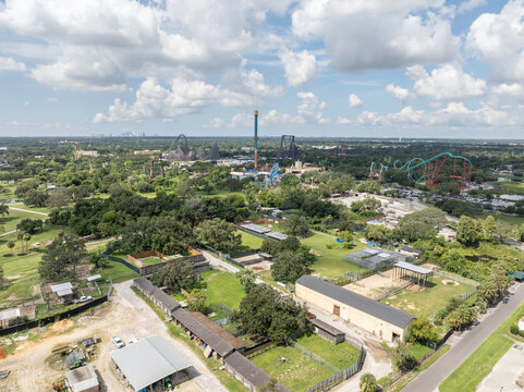 Tampa, Florida, United States - 10 July 2025: Aerial view of Busch Gardens Tampa Bay featuring roller coasters, lush greenery, and animal enclosures under a blue sky.