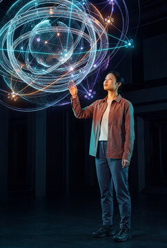 Scientist observing a holographic atomic model with orbital rings