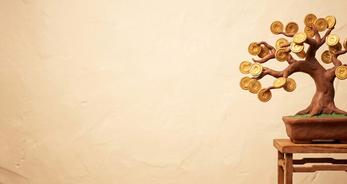 Plasticine bonsai money tree with shiny gold Chinese coins standing on a wooden stand against a warm wall with copy space.