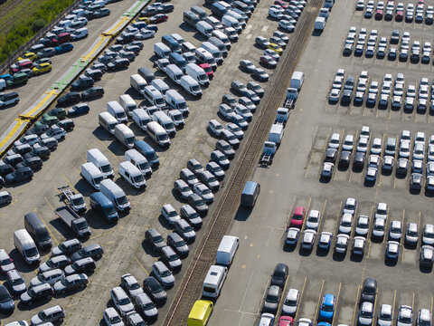 Dabrowa Gornicza, Poland - 09 August 2026: Aerial view of Autoterminal Slask Logistic Sp. z o.o. with rows of parked cars and vans in a large industrial vehicle storage facility.