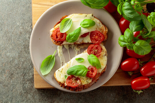 Hot open sandwiches with mozzarella, tomatoes and basil.
