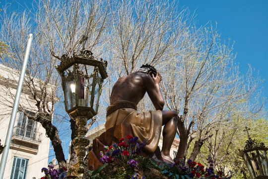 A Holy Week procession in Spain featuring a local religious brotherhood with hooded penitents and a float bearing religious images, which has been designated a site of international tourist interest.	