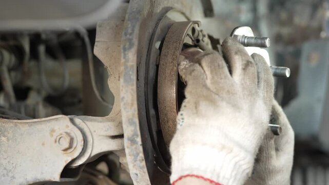 A rusty car wheel hub assembly exposed during brake repair.