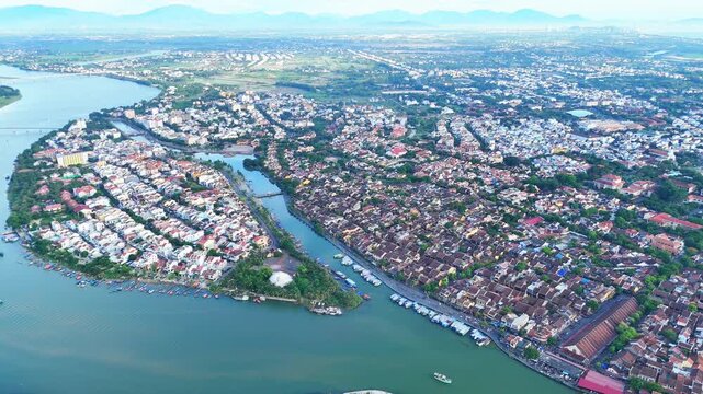 Aerial view of Hoi An Ancient Town, a World Heritage Site by Thu Bon and Hoai Rivers, with a view stretching to the South China Sea. Daylight drone.