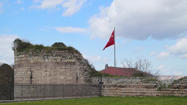 Turkish flag waving over the ancient Walls of Constantinople in Istanbul