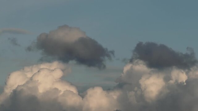 Dynamic clouds featuring bright white cumulus bases overlaid with darker cloud fragments ranging from slate gray to near-black.
