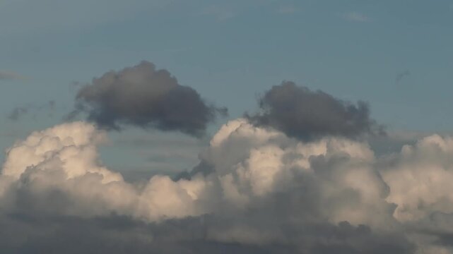 Dynamic clouds featuring bright white cumulus bases overlaid with darker cloud fragments ranging from slate gray to near-black.