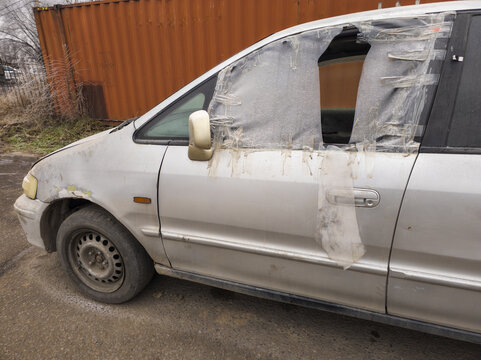 Damaged Silver Minivan with Plastic Covered Windows