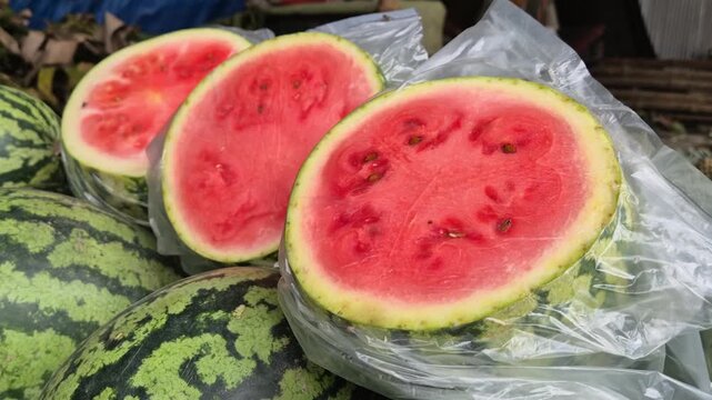 Sliced Crimson Sweet Watermelon Wrapped In Plastic Displayed At Market Stall