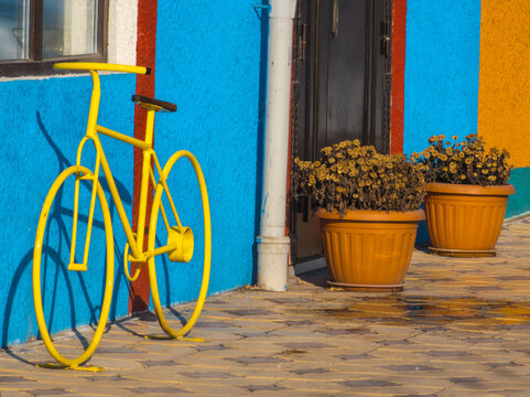 Bright Yellow Bicycle Sculpture in Colorful Urban Setting