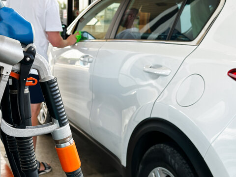 Cleaning vehicle window during refueling stop.
