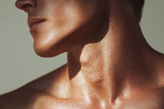 Glossy male neck and jawline with dewy skin catching light, close up showing texture and sheen conveying healthy skincare and subtle emotion