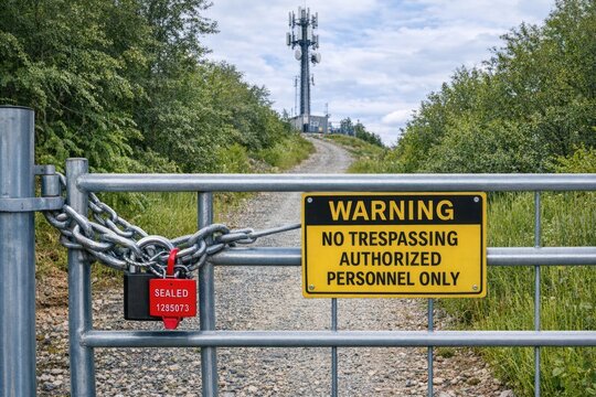 Warning sign on a gate with no trespassing and authorized personnel only text