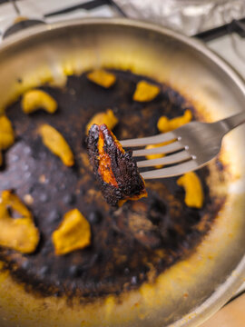 Burnt Food on Fork Over Dirty Frying Pan