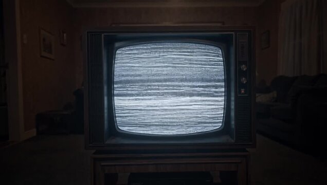 暗いリビングで砂嵐が流れるレトロなブラウン管テレビ