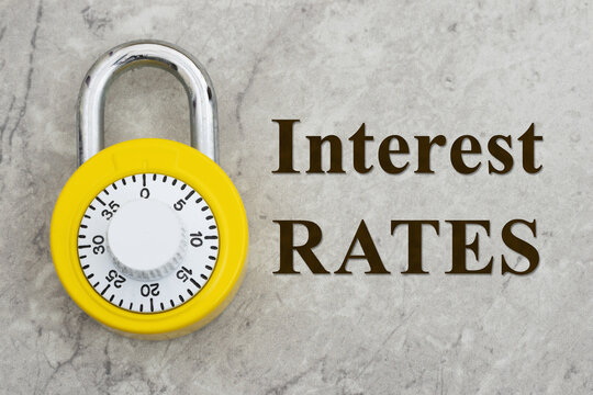 Interest Rates text with yellow combination lock on marble for locking in rates for loans