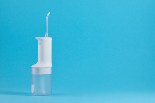 Water flosser for daily oral hygiene routine, providing effective teeth and gum cleaning on blue background
