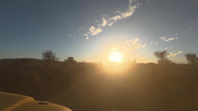 4x4 vehicle chasing enduro bikes on dirt trail raising dust in desert at sunset