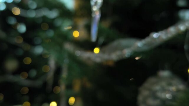 Crystal icicle hanging near defocused evergreen lights, magical holiday ambiance, artistic winter composition, sparkling seasonal decoration, warm festive interior mood, dreamy Christmas aesthetic.