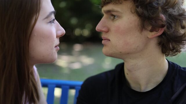 Young couple have an intimate face to face conversation on outdoor dates maintaining eye contact as attraction deepens and romantic feelings begin to develop naturally