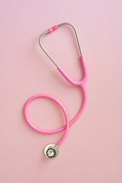 Pink stethoscope on vertical pink background symbolizing Breast Cancer Awareness month and medical care support and prevention