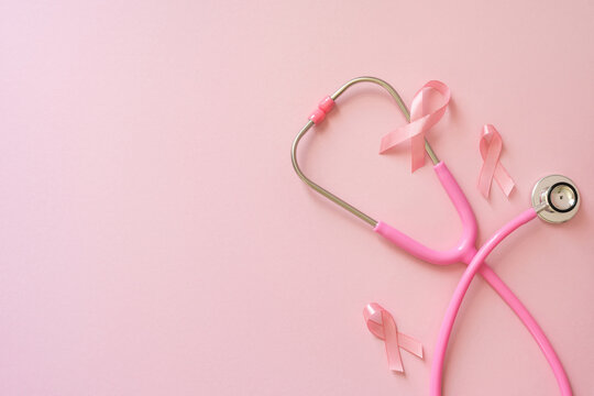 Breast cancer awareness month concept with pink stethoscope and ribbons on soft pink background promoting screening and care