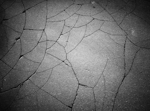 Multiple cracks on the city asphalt road texture backdrop