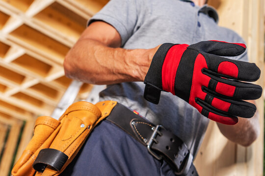 Worker prepares to put on gloves for construction task