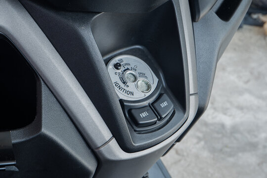 Motorcycle Ignition Switch and Key Hole Close Up with Fuel and Seat Release Buttons on Scooter Dashboard