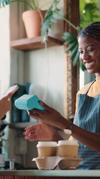 Happy woman, customer and barista with pos machine for payment, purchase or checkout in cafe. Female person, tap to pay and phone with tech or smile for order, transaction or service in coffee shop